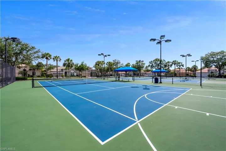 View of tennis court featuring fence and community basketball court