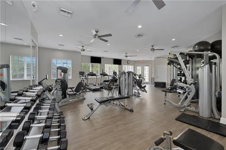 Gym featuring a ceiling fan, recessed lighting, and wood finished floors