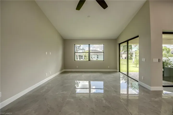 Empty room featuring tile patterned floors, a healthy amount of sunlight, and ceiling fan