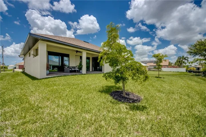 Rear view of house with a yard, a patio area, and ceiling fan