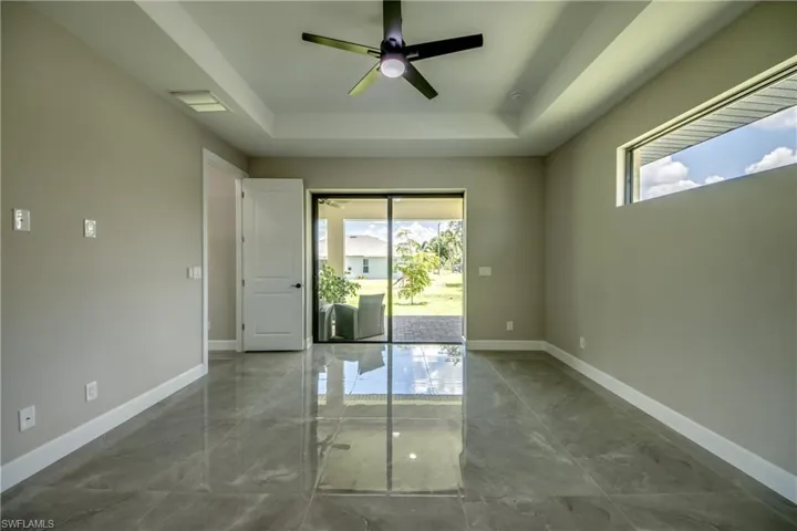 Tiled MASTER BEDROOM featuring ceiling fan and a tray ceiling