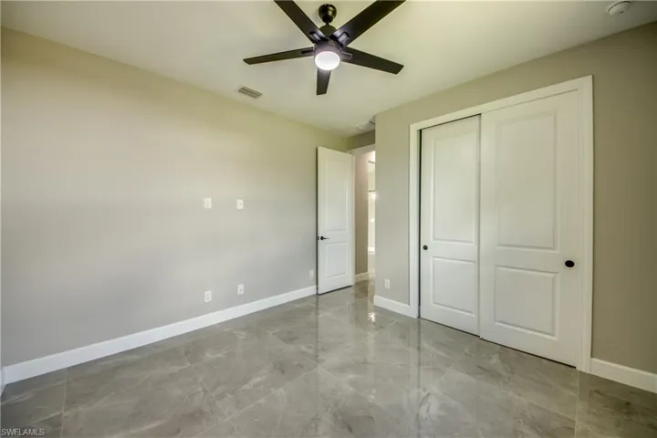 Unfurnished 3RD bedroom featuring a closet, light tile patterned floors, and ceiling fan DIFFERENT VIEW