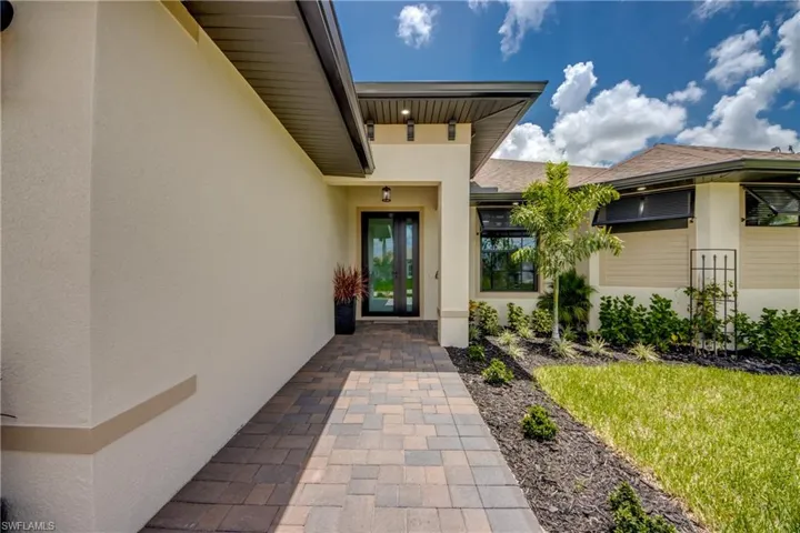 View of exterior entry, Bahama Shutters on the Windows to the right add Elegance