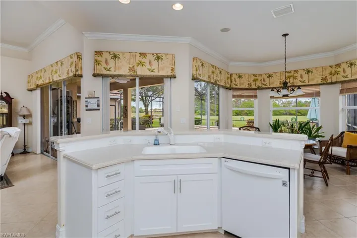Kitchen featuring dishwasher, light tile patterned floors, white cabinetry, open floor plan, and ornamental molding