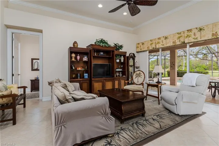 Living area featuring a ceiling fan, crown molding, light tile patterned flooring, and recessed lighting