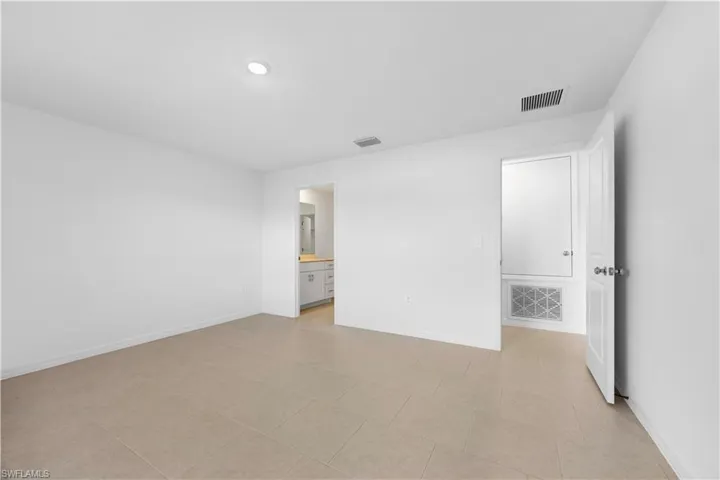 Unfurnished bedroom featuring baseboards and ensuite bath