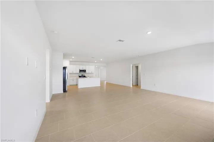 Unfurnished living room with recessed lighting and light tile patterned floors