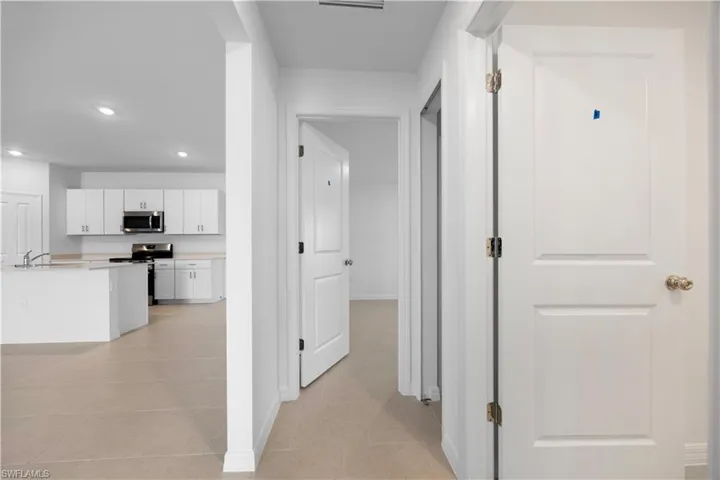 Corridor with recessed lighting and light tile patterned flooring