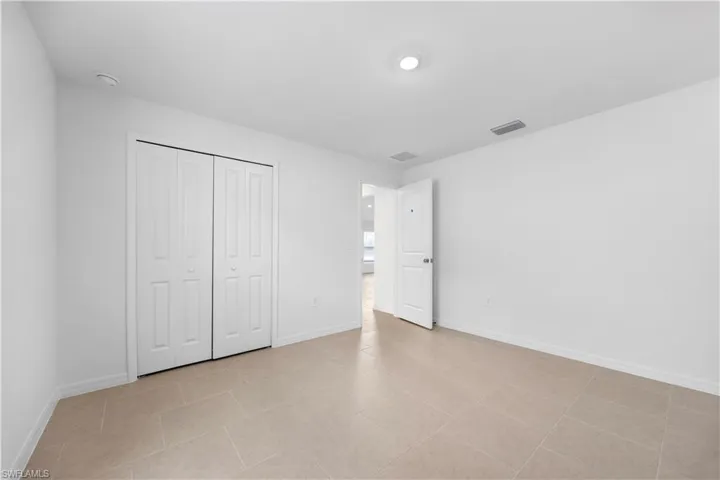 Unfurnished bedroom featuring a closet and light tile patterned floors