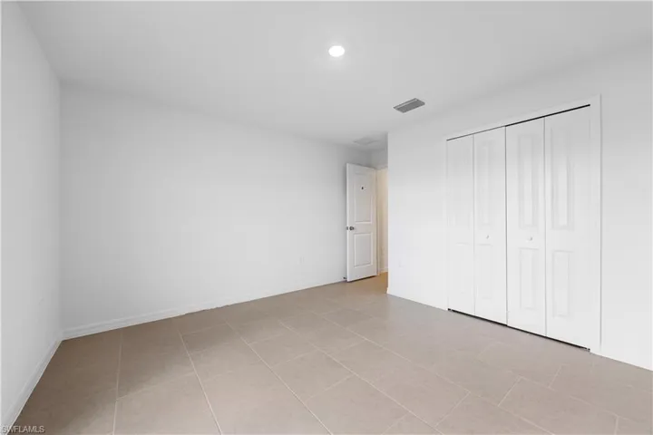 Unfurnished bedroom with a closet and light tile patterned floors