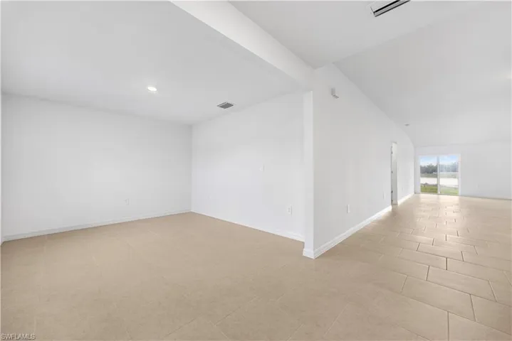 Spare room with baseboards and vaulted ceiling