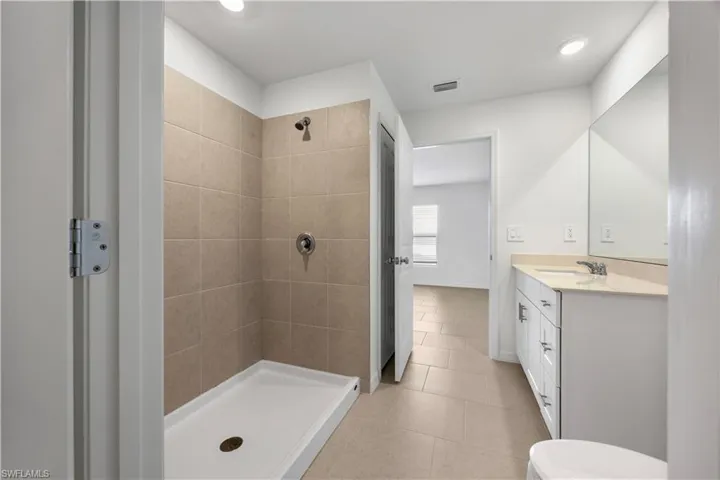 Bathroom with vanity, a stall shower, light tile patterned floors, and recessed lighting