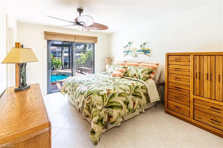 Bedroom with access to outside, light tile patterned floors, and ceiling fan
