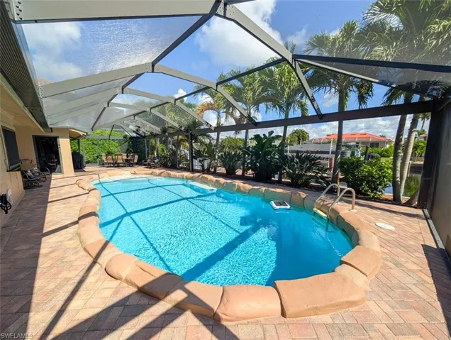 Swimming pool with a sunroom, a lanai, and a patio