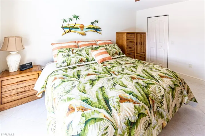 Bedroom featuring light tile patterned floors, a closet, and a ceiling fan