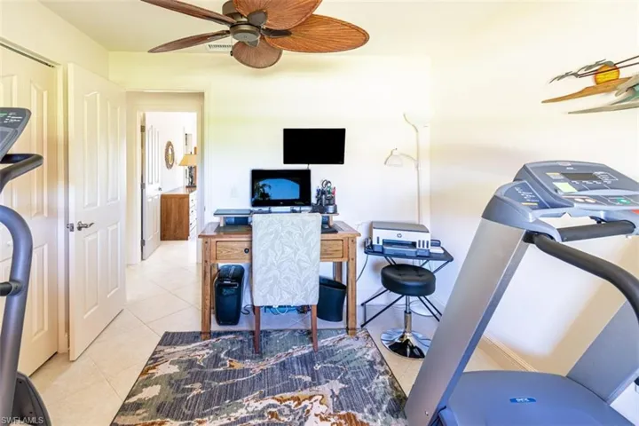 Office space with light tile patterned flooring and a ceiling fan