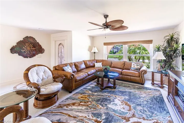 Living area with a ceiling fan and baseboards