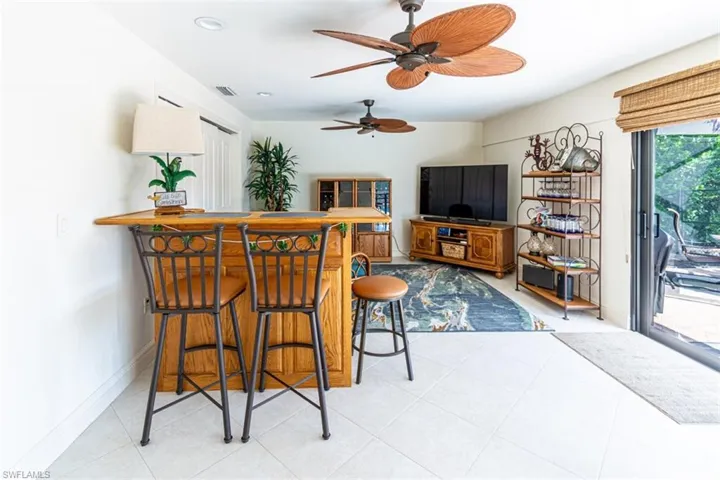 Bar area featuring ceiling fan, light tile patterned floors, and recessed lighting