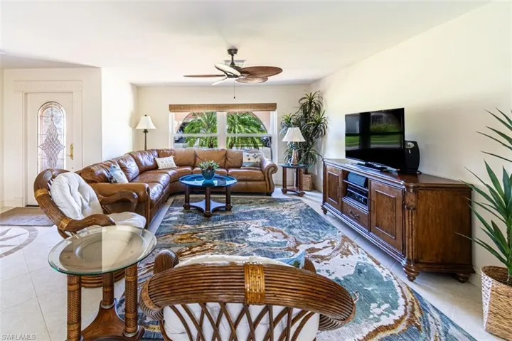 Living room featuring light tile patterned floors and ceiling fan
