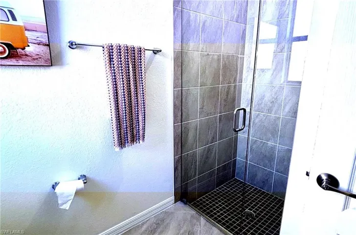 Full bathroom featuring a shower stall