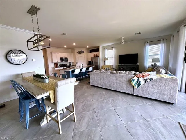 Dining area featuring crown molding, light tile patterne