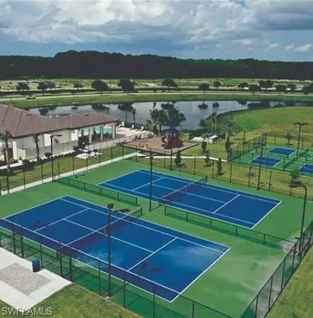 View of tennis court with a water view