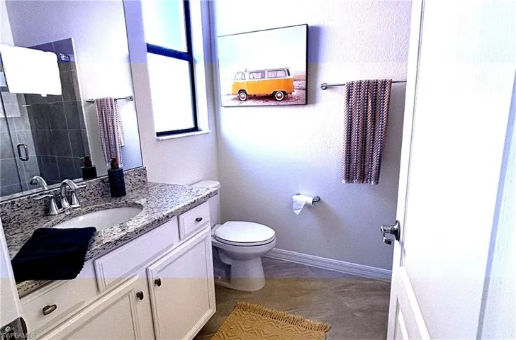 Bathroom with vanity, a textured wall, and a shower stall