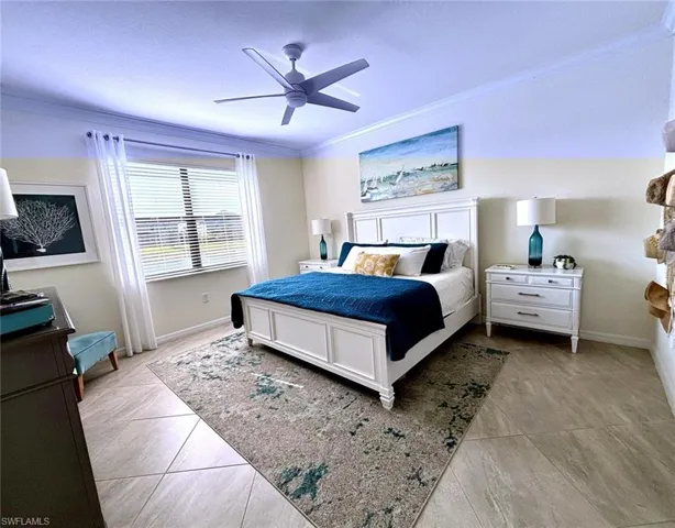 Bedroom featuring a ceiling fan, ornamental molding, and light tile patterned floors