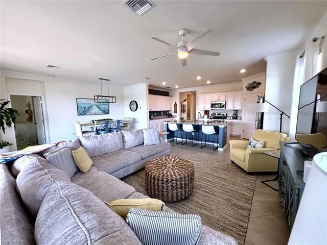 Living room featuring a ceiling fan, ornamental molding, and recessed lighting