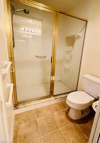 Full bath with a stall shower and tile patterned floors