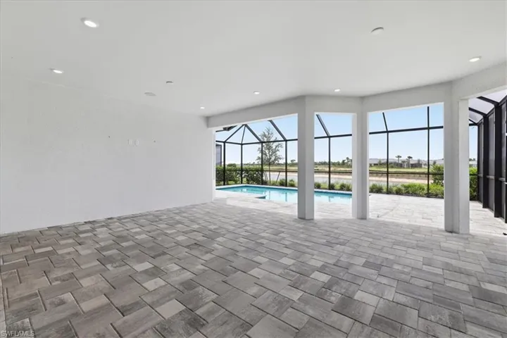 Spacious screened lanai featuring multi-tone paver flooring and recessed lighting