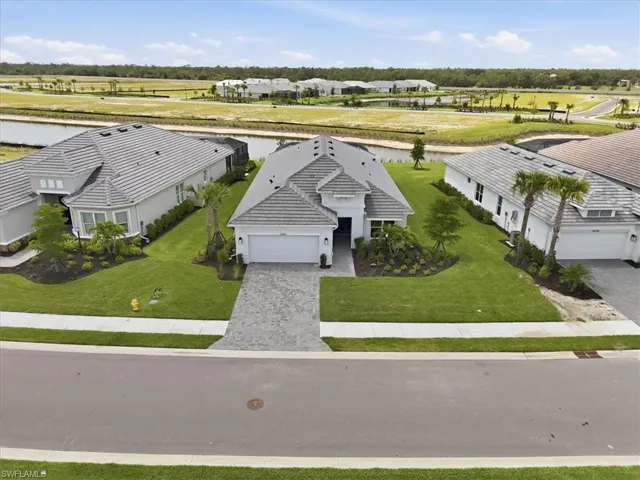Contemporary stucco home featuring a gray tile roof, paver driveway, and a two-car garage