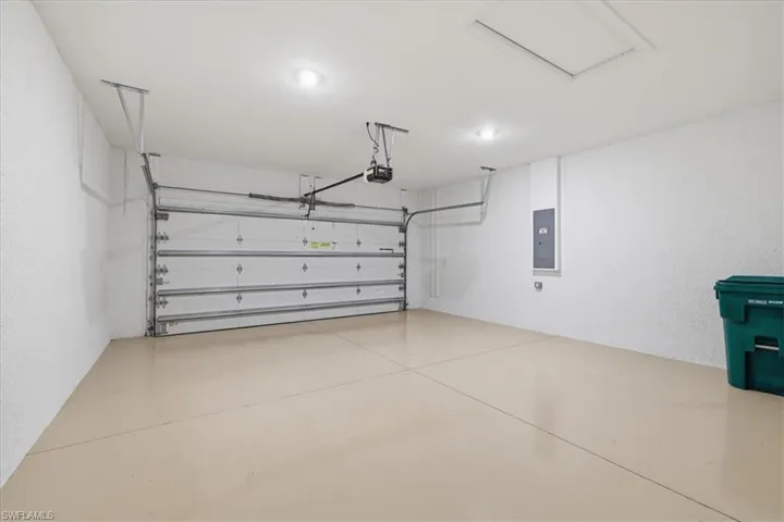 Spacious garage featuring a light-toned, finished floor, a sectional overhead door with opener, and recessed ceiling lighting
