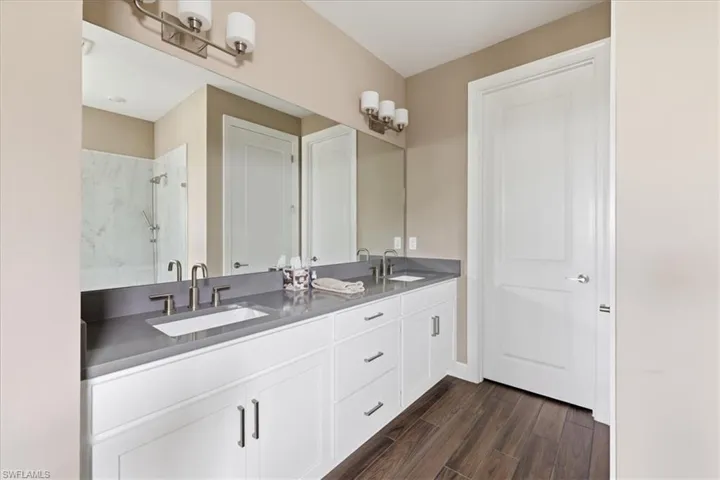 Dual vanity with a stone countertop, undermount sinks, and brushed nickel fixtures