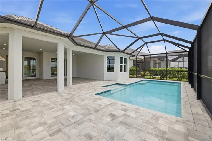 Screened outdoor living area featuring a rectangular pool with steps