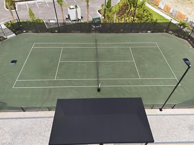 Regulation tennis court with a green playing surface and white line markings