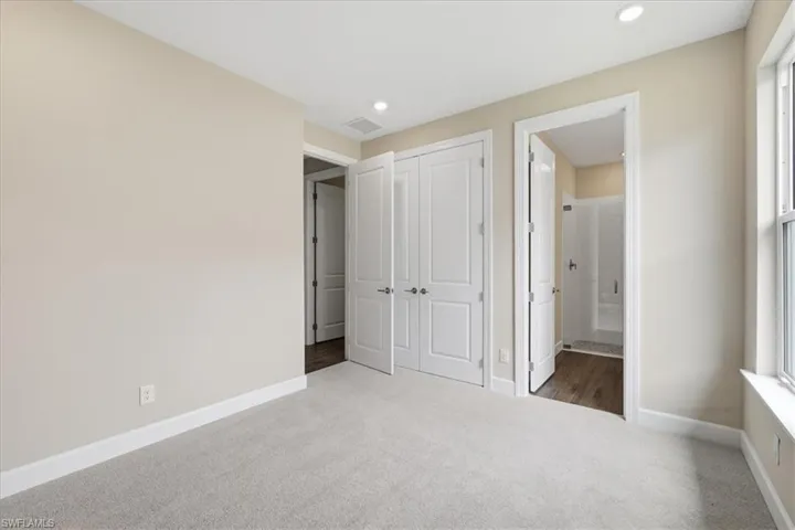 Carpeted room featuring neutral wall tones, recessed lighting, and white trim