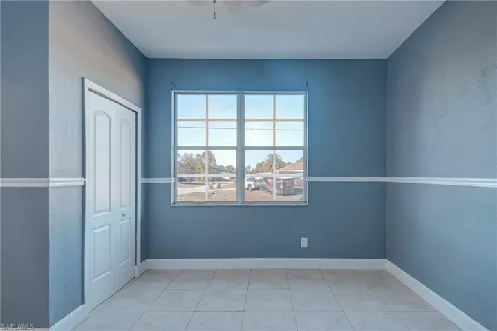 Spare room featuring light tile patterned floors and a textured wall