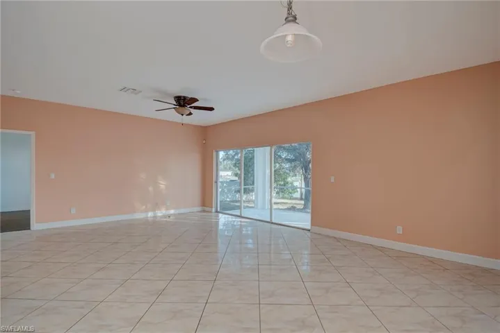 Empty room featuring ceiling fan and light tile patterned floors