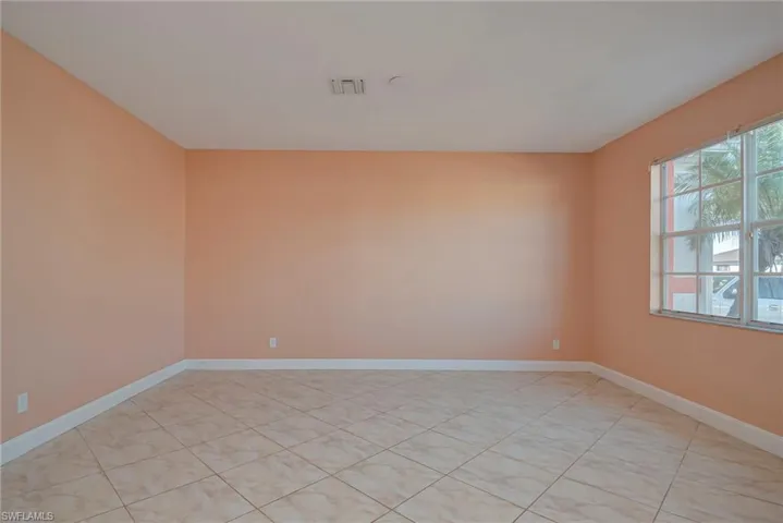 Spare room featuring baseboards and light tile patterned floors