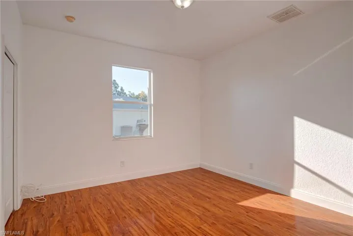 Spare room featuring baseboards and light wood finished floors