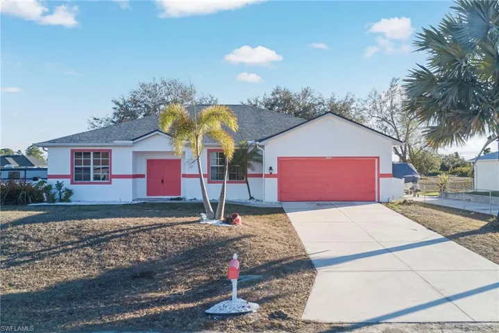 Single story home featuring stucco siding, an attached garage, a shingled roof, and driveway