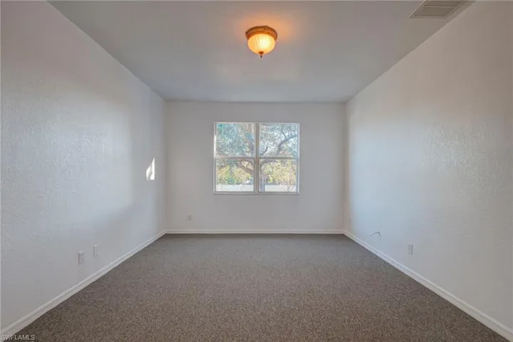 Empty room featuring a textured wall and carpet flooring