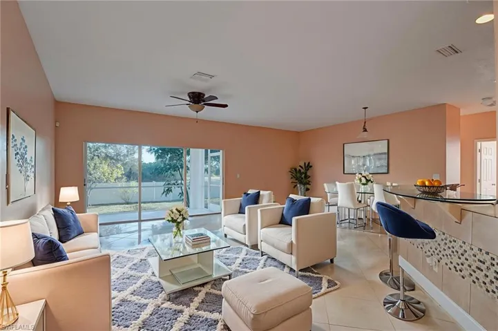 Living room featuring light tile patterned floors and a ceiling fan