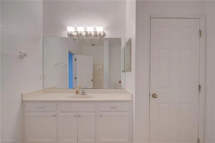 Bathroom with vanity and a textured wall