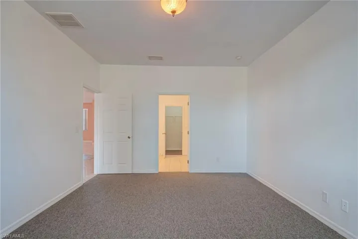 Unfurnished bedroom with carpet floors and baseboards