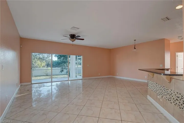 Unfurnished room with ceiling fan and light tile patterned floors