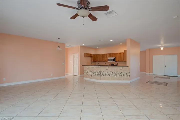 Unfurnished living room featuring light tile patterned floors, ceiling fan, and recessed lighting