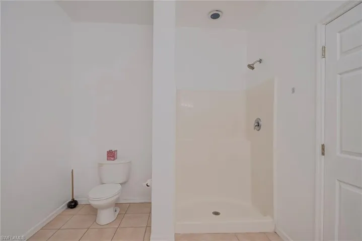 Bathroom featuring light tile patterned floors and a stall shower