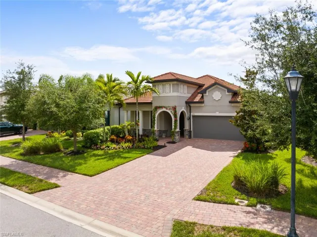 Mediterranean / spanish house featuring a garage and a front lawn